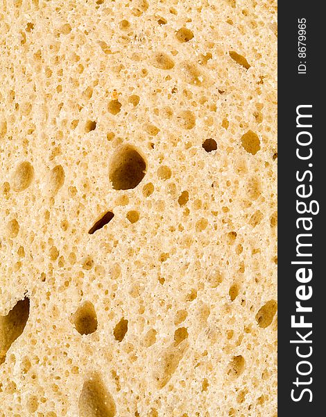 A close up of the texture of a slice of white bread. A close up of the texture of a slice of white bread