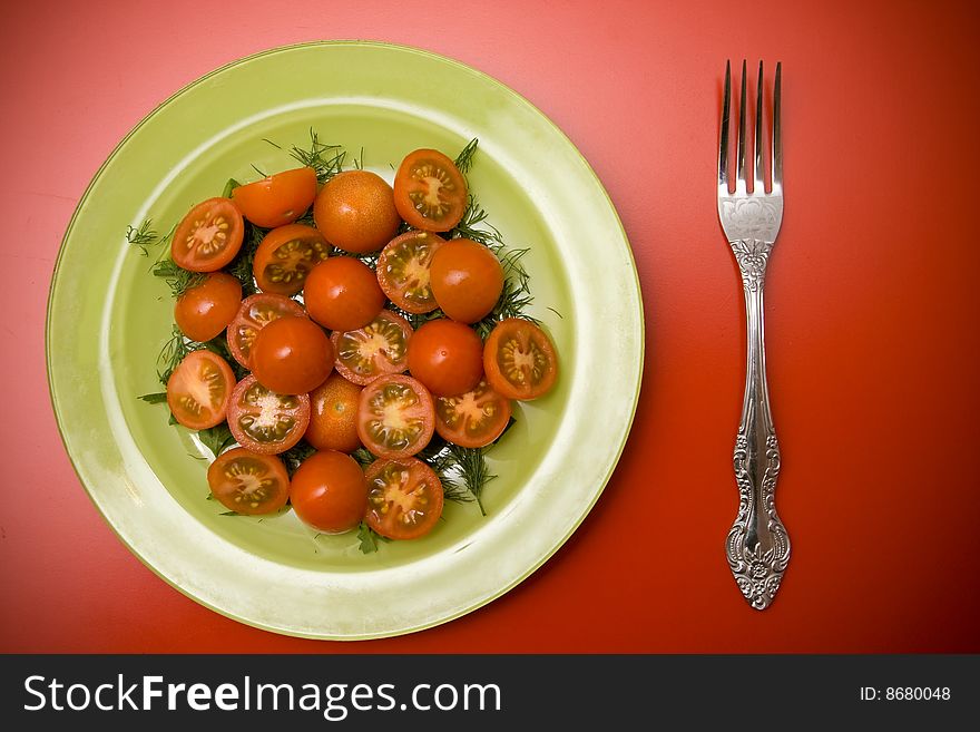 Tomato salad on the green plate on the red table. Tomato salad on the green plate on the red table