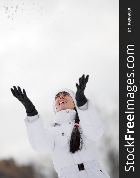 Winter portrait of a happy girl throwing snowballs over her head - Shallow DOF. Winter portrait of a happy girl throwing snowballs over her head - Shallow DOF