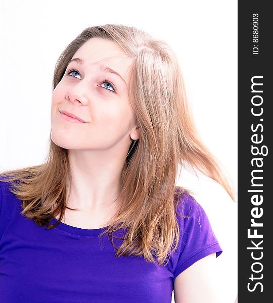 Studio Shot of a beautiful girl in a blue t-shirt dressing her hair, isolated on white background. Studio Shot of a beautiful girl in a blue t-shirt dressing her hair, isolated on white background