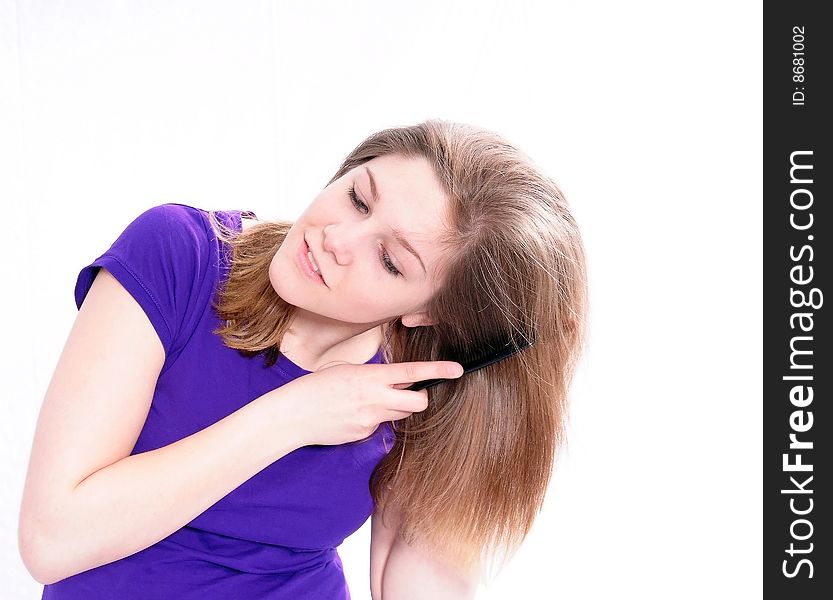 Studio Shot of a beautiful girl in a blue t-shirt dressing her hair, isolated on white background. Studio Shot of a beautiful girl in a blue t-shirt dressing her hair, isolated on white background