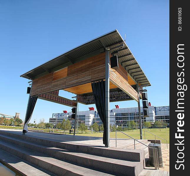 Wooden wood grained stage atop concrete steps below blue sky