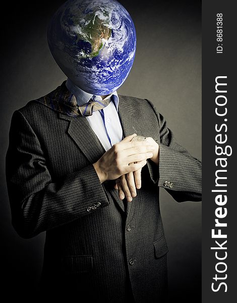 Businessman with planet instead of head looking to his watch. Conceptual creativity image.Earth in this montage provided by NASA (http://visibleearth.nasa.gov/). Businessman with planet instead of head looking to his watch. Conceptual creativity image.Earth in this montage provided by NASA (http://visibleearth.nasa.gov/)