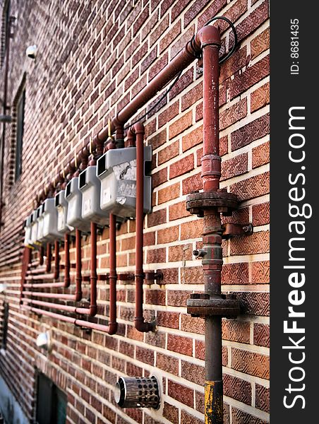 Gas Meters in Perspective hung on stark red brick wall in perspective