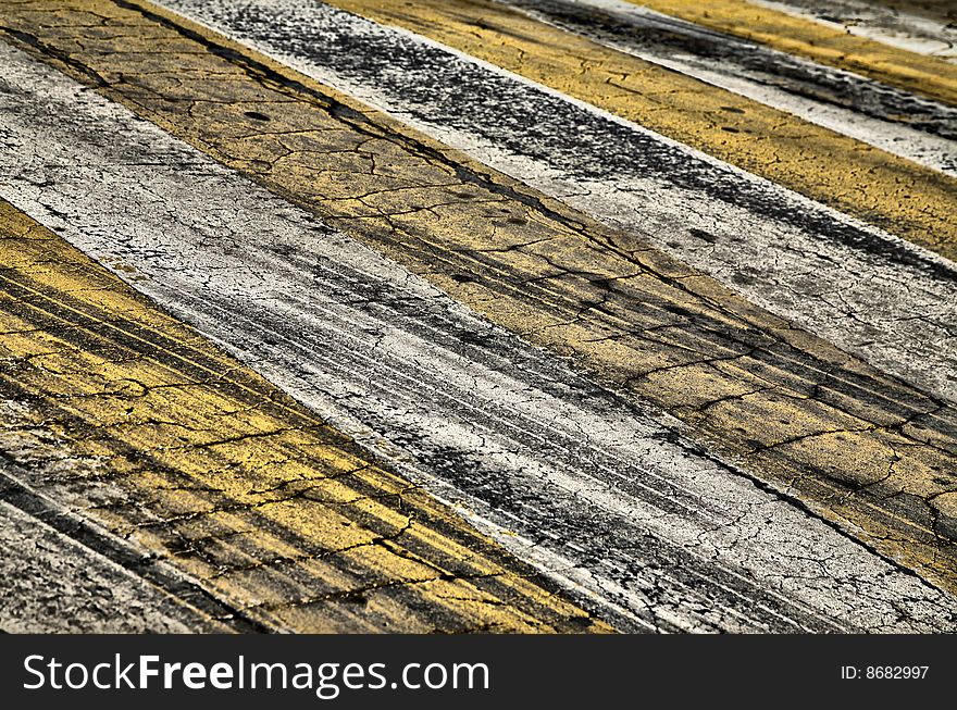 Cracked Yellow and White Paint on Black Asphalt Road