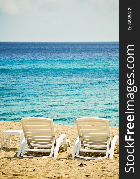 Two empty beach chairs by the blue sea. Two empty beach chairs by the blue sea