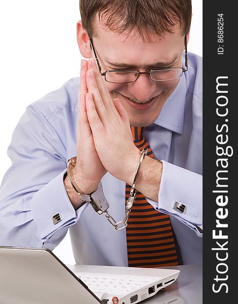 Handsome young businessman bound to laptop with handcuffs. Handsome young businessman bound to laptop with handcuffs