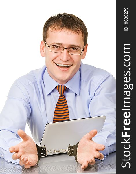 Handsome young businessman bound to laptop with handcuffs. Handsome young businessman bound to laptop with handcuffs