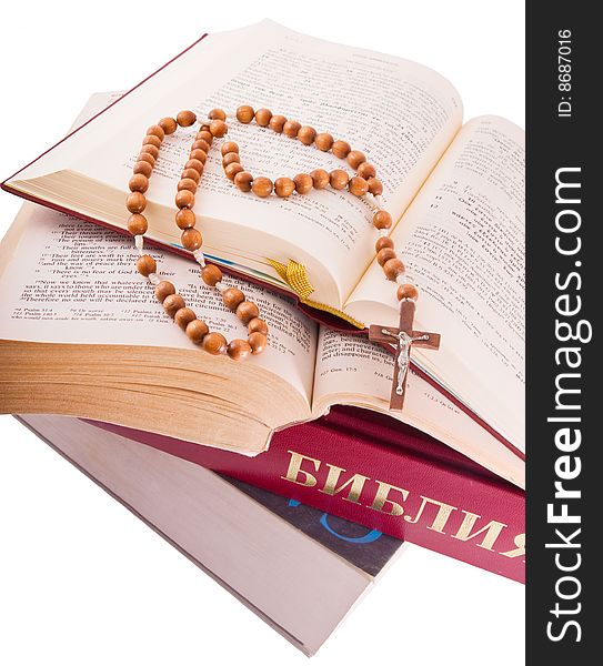 Open Holy Bible lying on stack of old books with glasses, cross and beads. Open Holy Bible lying on stack of old books with glasses, cross and beads