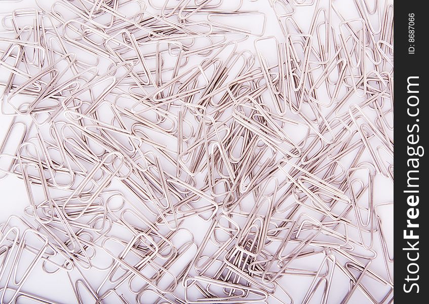 Heap of steel grey paperclips on white background