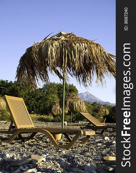 Yellow tropic parasols and beach chairs in sunny weather. Yellow tropic parasols and beach chairs in sunny weather