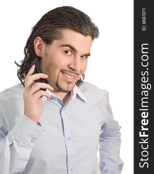 Young dark haired caucasian man in light blue striped shirt holds mobile phone and smiles isolated on white. Young dark haired caucasian man in light blue striped shirt holds mobile phone and smiles isolated on white