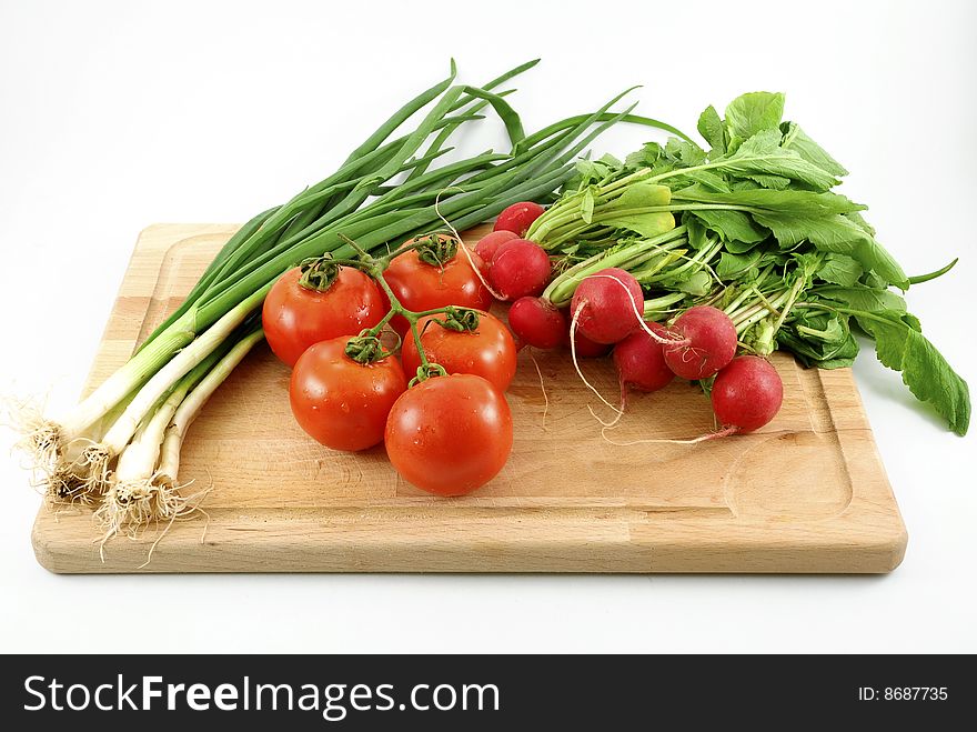 Fresh vegetables on chopping board against white background