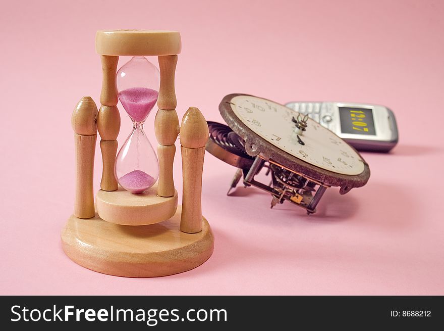 Modern and old fashioned clocks,  Low depth of field, focus on hourglass. Modern and old fashioned clocks,  Low depth of field, focus on hourglass