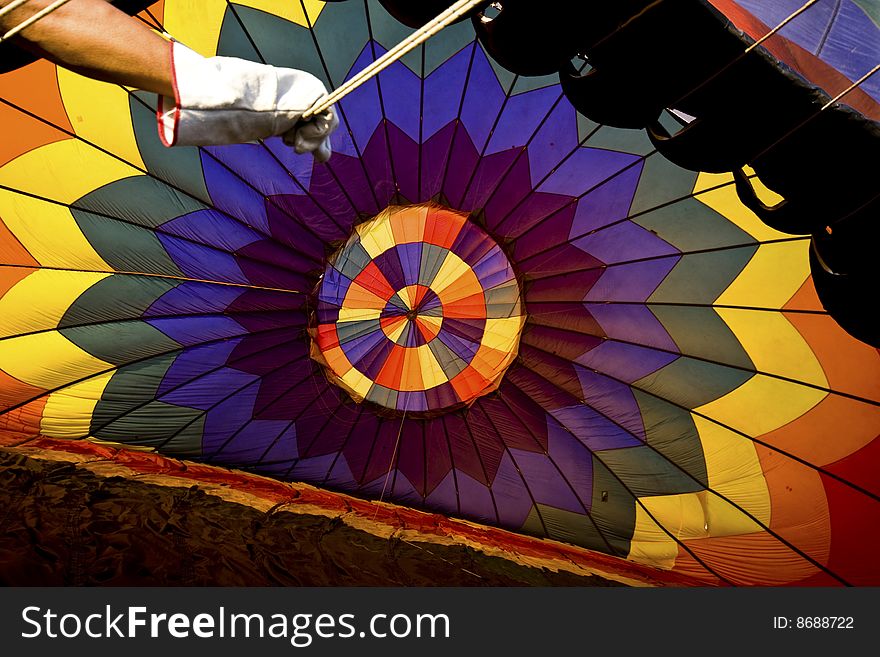 Balloonist handling the ropes to control the inflation of the hot air balloon. Balloonist handling the ropes to control the inflation of the hot air balloon