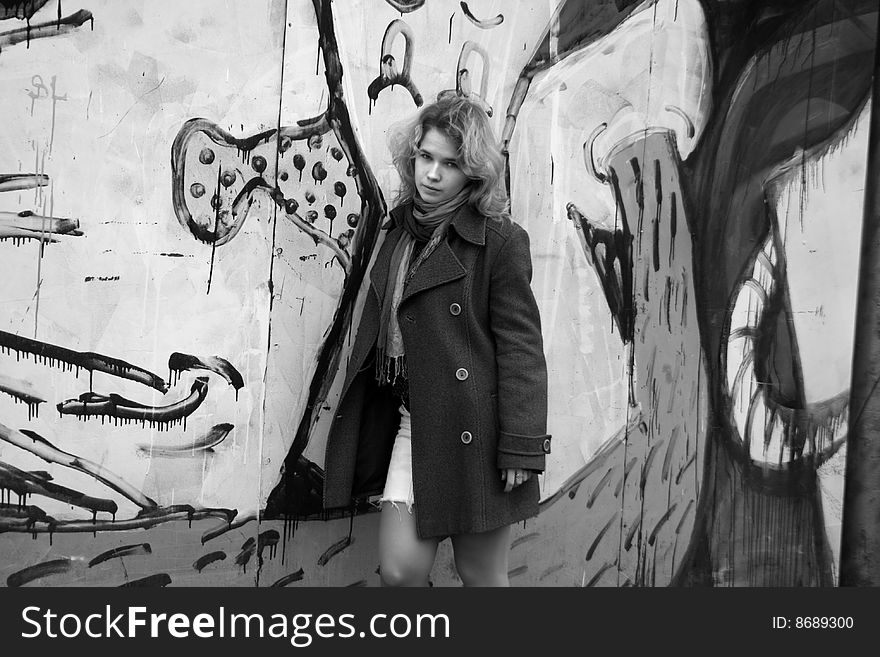 Girl standing in front of a graffiti wall. Girl standing in front of a graffiti wall