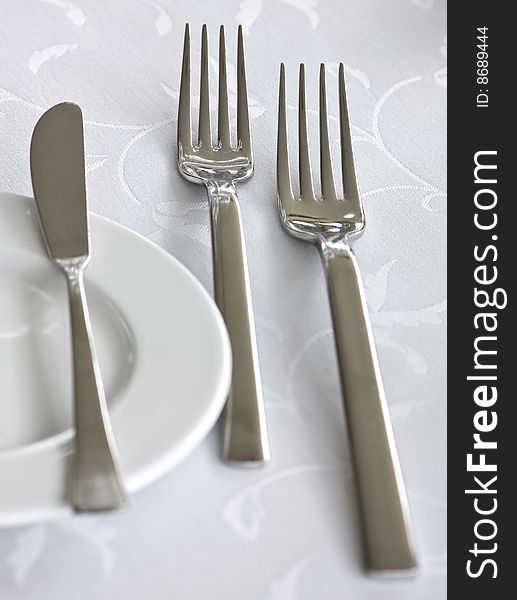 Knife, fork and plate on a table. Knife, fork and plate on a table