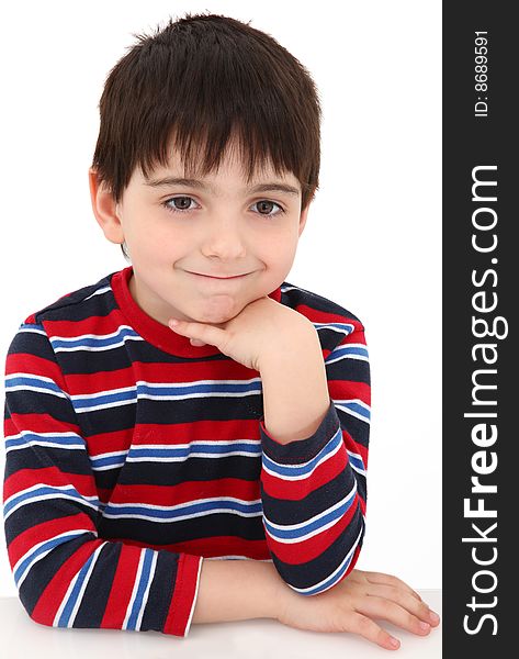 Adorable five year old boy making bored grin expression.  Face resting on hand.