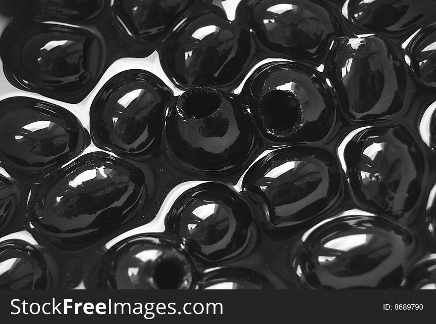 Black wet olives as background.