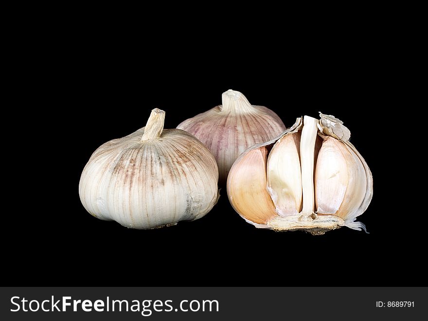 Garlic bulbs whole and half over the black background