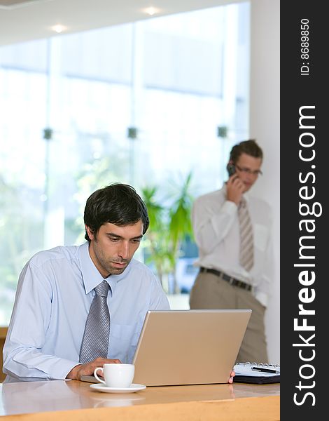 Confident young business man working on laptop.