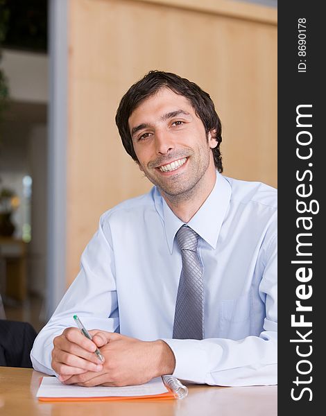 Portrait of smiling business man working by desk. Portrait of smiling business man working by desk.