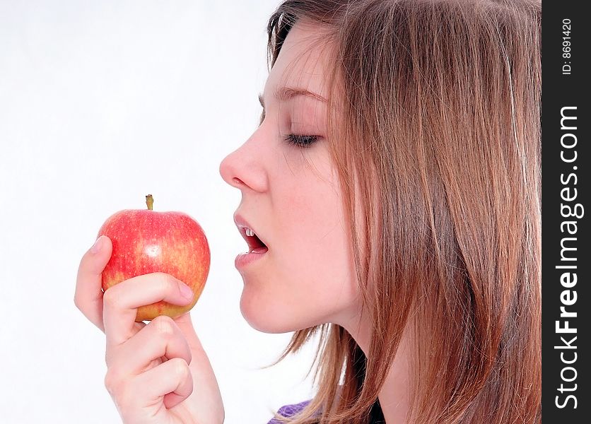 A studio shot of a beautiful girl holding an apple in her hand, isolated on white background. A studio shot of a beautiful girl holding an apple in her hand, isolated on white background