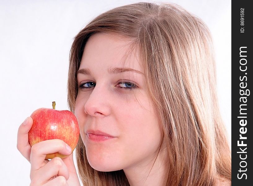 A studio shot of a beautiful girl holding an apple in her hand, isolated on white background. A studio shot of a beautiful girl holding an apple in her hand, isolated on white background