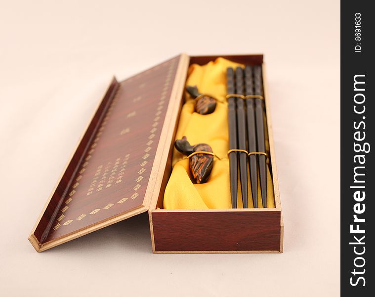 Set from the Chinese chopsticks in a box with hieroglyphs it is isolated on the white. Set from the Chinese chopsticks in a box with hieroglyphs it is isolated on the white