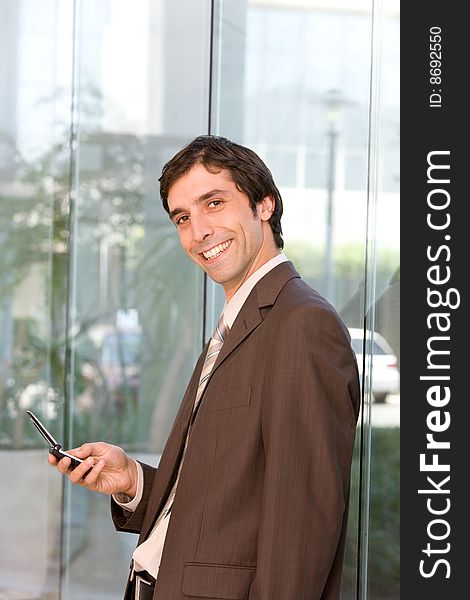 Portrait of confident smiling business man holding cell phone.