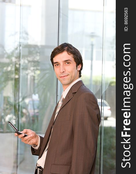 Portrait of confident business man holding cell phone.