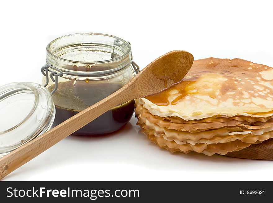 Pancakes, wooden spoon and  glass jar with honey isolated on a white background. Pancakes, wooden spoon and  glass jar with honey isolated on a white background