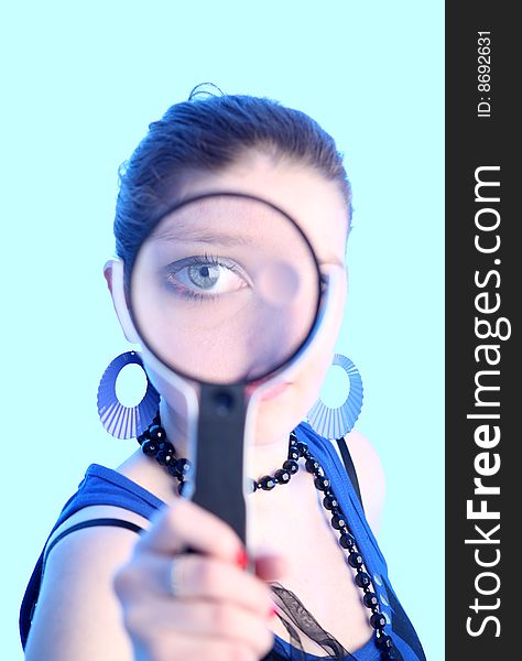 Eye of the girl in a magnifier covered by blue light