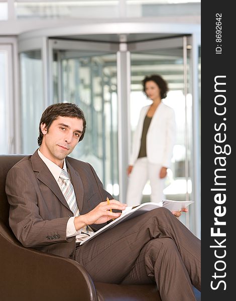 Confident business man sitting and reading document. Confident business man sitting and reading document.