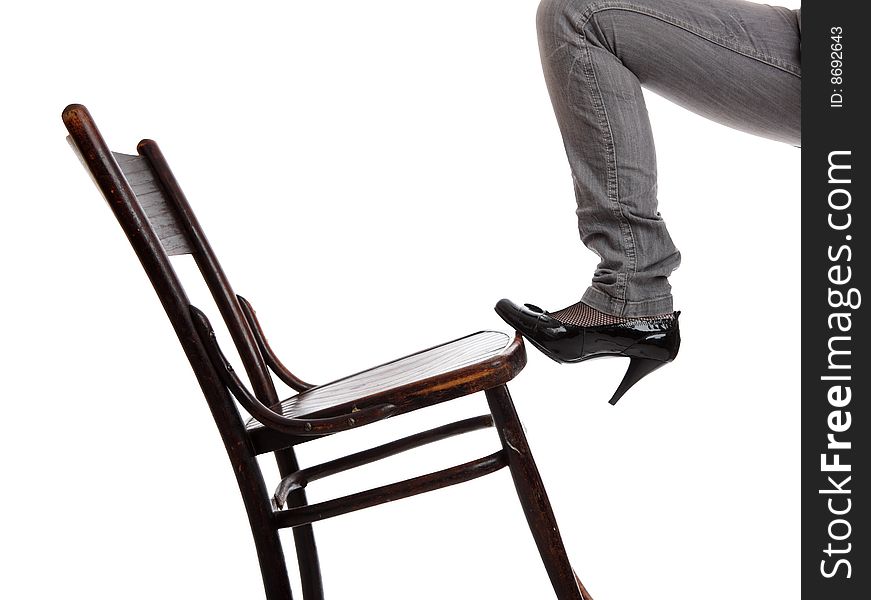 The female leg in jeans pushes a chair. The female leg in jeans pushes a chair