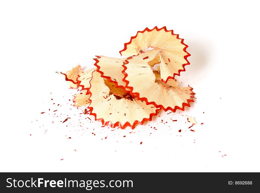 Red pencil shavings on white paper background