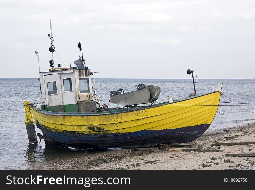 Yellow fisher boat on the seashore