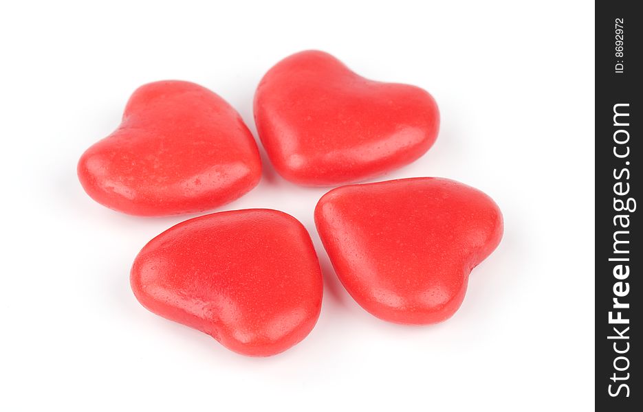Four heart shaped candies on a white background
