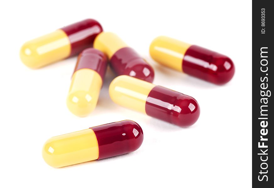 Several drug filled capsules on a white background