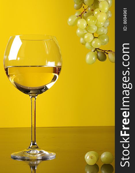 A glass of white wine with grapes. A glass of white wine with grapes