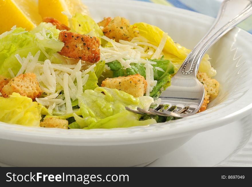 Closeup of freshly made caesar salad and lemon. Closeup of freshly made caesar salad and lemon.