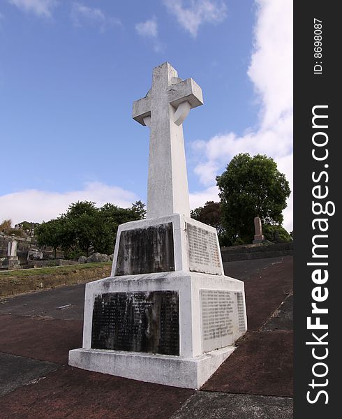 Photo image of a cemetery cross with blue sky in the background