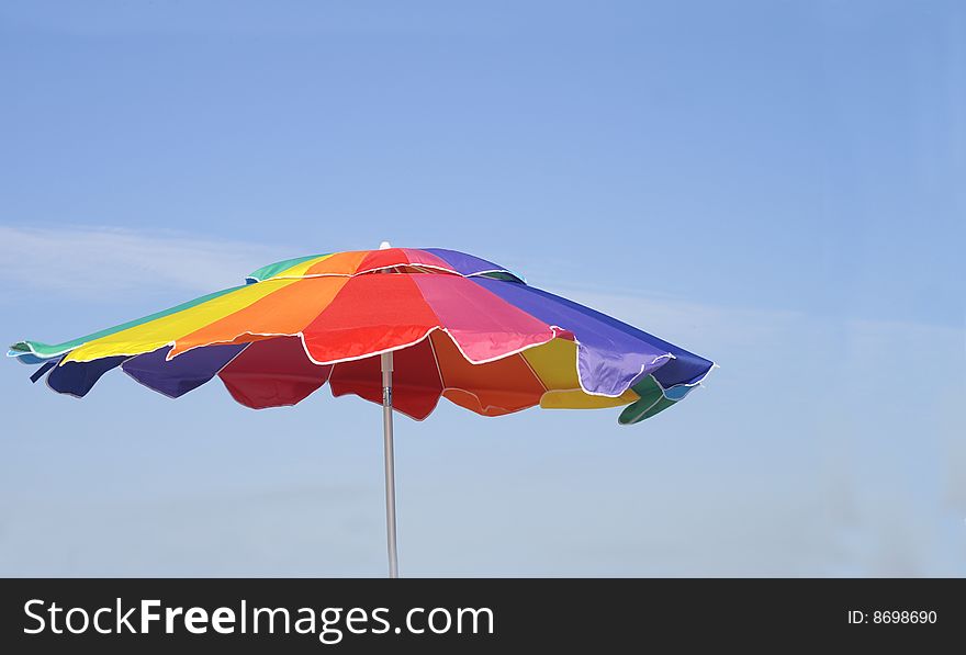 Beach umbrella blowing gently in the breeze at a Gulf Coast beach. Beach umbrella blowing gently in the breeze at a Gulf Coast beach.