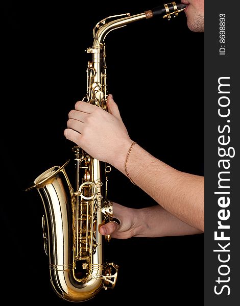 Golden alto saxophone in hands of young man