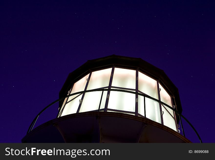 Fresnel lens lighthouse against a star filled sky