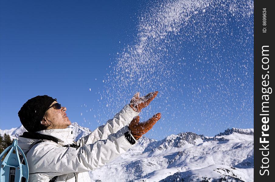 Woman throwing some snow in the air in mountain. Woman throwing some snow in the air in mountain