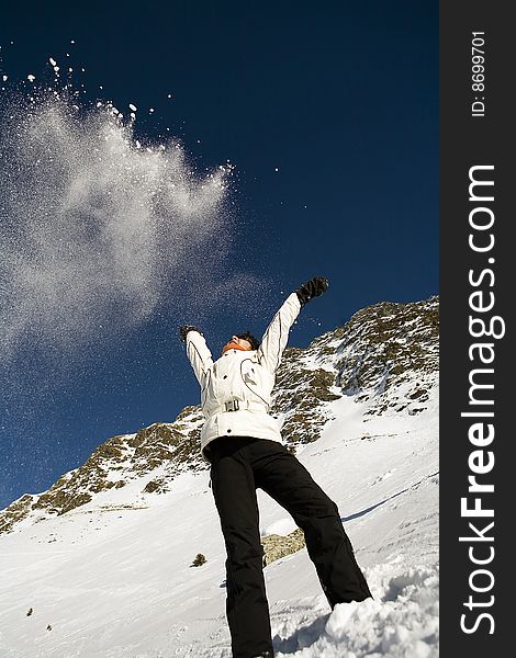 Woman throwing some snow in the air in mountain. Woman throwing some snow in the air in mountain