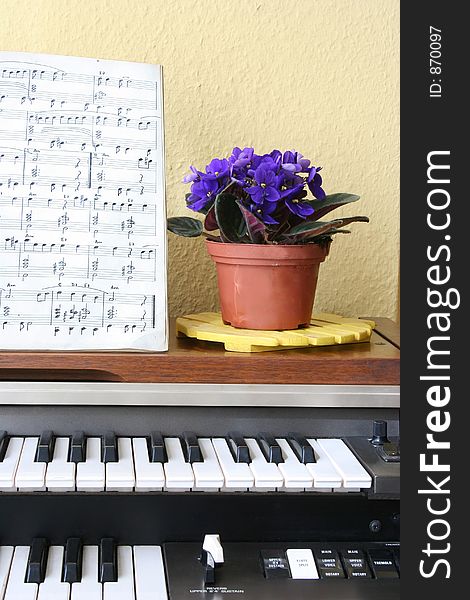 Piano, sheetmusic and violets. Piano, sheetmusic and violets