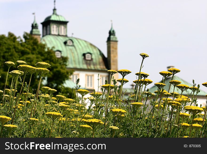 Castel of fredensborg in denmark a sunny summer day, with flowers in the foreground