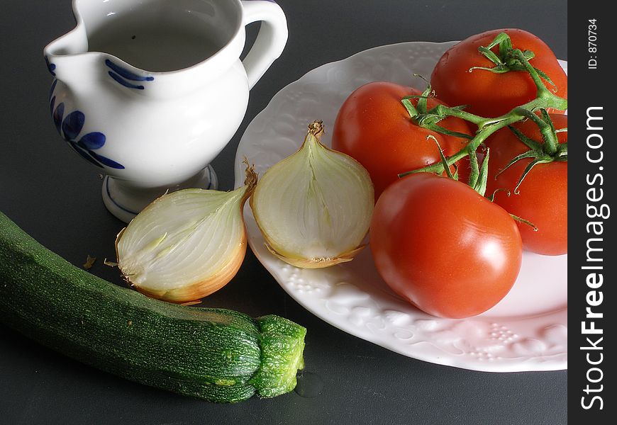 Tomato,onion and zucchini still life with a white and blue chinaware. Tomato,onion and zucchini still life with a white and blue chinaware